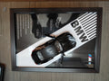 BMW M Series gloss black die-cast model in dark wood shadow box with BMW M branded backdrop and performance specs